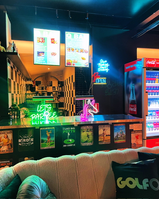 The Q Bar with neon signage and illuminated menus at Golf Q Meadowbank